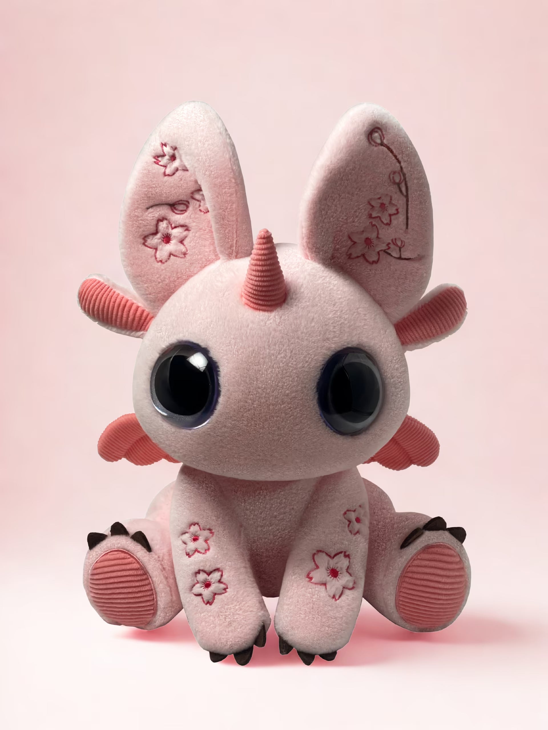 Pink plush toy Bloom with large eyes and a small horn on a cherry pink background Skybloom 